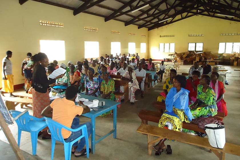 Community members filling a hall during a Kiyunga Social Service Centre meeting on rights and local accountability.