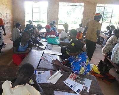Participants reading printed information materials together at a community workshop.
