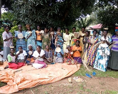 Women and children gathered outdoors at the close of a community meeting.